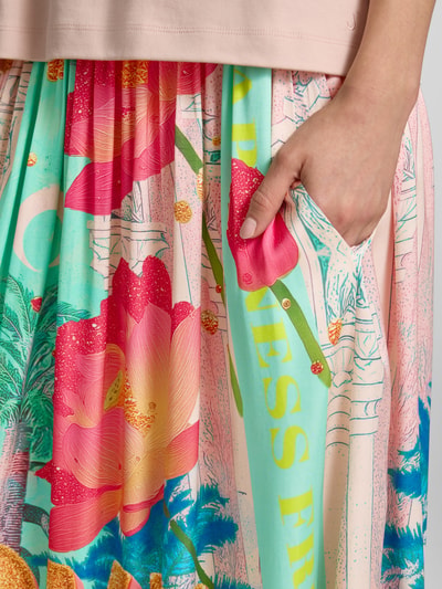 Frauenmodel trägt Midirock aus reiner Viskose mit Allover-Motiv-Print von miss goodlife, bunte Farben, elastischer Bund, Nahaufnahme Oberkörper.