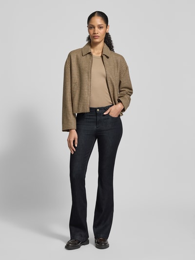 Frauenmodel trägt Flared Fit Jeans im 5-Pocket-Design Modell 'Shakira' von BRAX, dunkle Farbe, Baumwoll-Mix, Ganzkörperansicht von vorne.