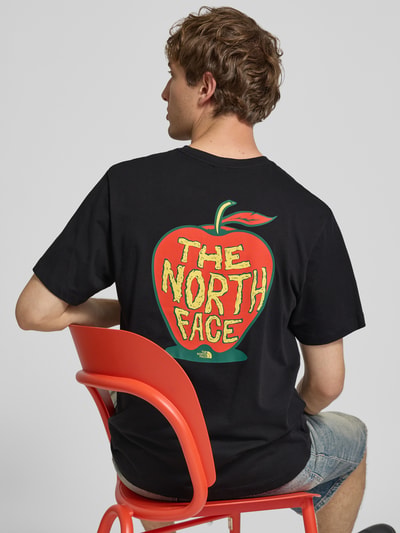 Männermodel trägt Regular Fit T-Shirt mit Motiv-Print auf der Rückseite von The North Face in Schwarz, reine Baumwolle, Ganzkörperansicht Rückansicht.
