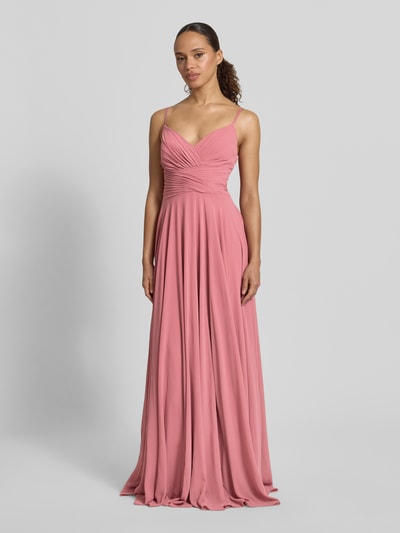 Frauenmodel trägt Abendkleid mit Drapierungen und V-Ausschnitt von Mascara in Altrosa, Maxikleid, Taillierter Schnitt, Ganzkörperansicht von vorne. Rückenlänge bei Größe 36: 128 cm, Brustweite 32 cm. Fließender Stoff mit feiner, glatter Textur.