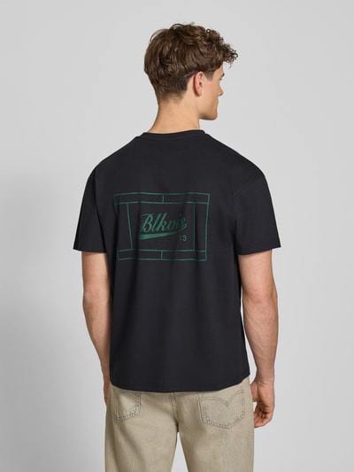 Männermodel trägt Regular Fit T-Shirt mit Logo-Print von BLKVIS aus reiner Baumwolle, Rundhalsausschnitt, schwarze Grundfarbe, Rückenlänge 67 cm bei Größe M, Ganzkörperansicht Rückansicht.