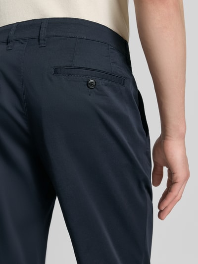 Männermodel trägt Chino mit Eingrifftaschen von Christian Berg Men aus Baumwoll-Elasthan-Mix in Dunkelblau, Detailaufnahme Rückansicht.