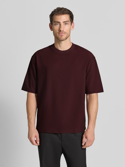 Männermodel trägt T-Shirt mit Strukturmuster und Rundhalsausschnitt von Emporio Armani, dunkelrot, Modern Fit, Nahaufnahme Oberkörper.