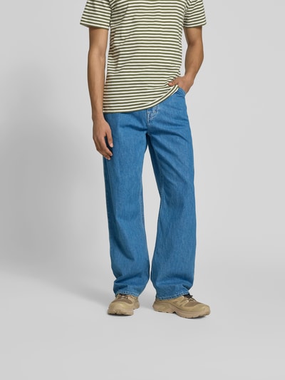 Männermodel trägt Straight Fit Jeans mit Logo-Patch von Closed aus reiner Baumwolle in Blau, Eingriff- und Gesäßtaschen, Ganzkörperansicht von vorne.