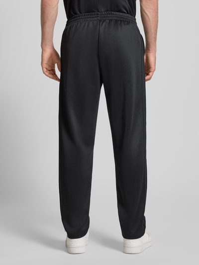 Männermodel trägt Straight Fit Sweatpants mit elastischem Bund von adidas Originals, schwarz, Material-Mix, Rückansicht Ganzkörperansicht.