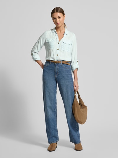 Modelka nosi Relaxed Fit Hemdbluse aus reiner Viskose Modell 'BUMPY' od Vero Moda, paski two tone, długie rękawy, widok całej sylwetki z przodu.