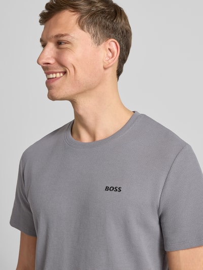 Männermodel trägt Regular Fit T-Shirt aus Baumwoll-Mix von BOSS, Optik: Unifarben, Waffel-Struktur, Rundhals, Kurzarm, Nahaufnahme Oberkörper.