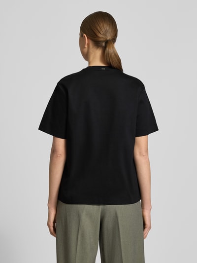 Vrouwenmodel draagt Relaxed Fit T-Shirt uit puur katoen model 'EHARPA' van BOSS, effen zwart, ronde hals, korte mouw, label stitching, pure katoen, geheel achteraanzicht.