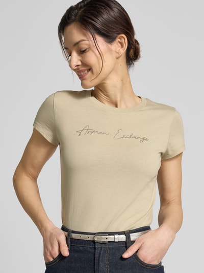 Frauenmodel trägt T-Shirt mit Logo und Rundhalsausschnitt von ARMANI EXCHANGE, Reine Baumwolle, Slim-Fit, dezente Farbe, Nahaufnahme Oberkörper.