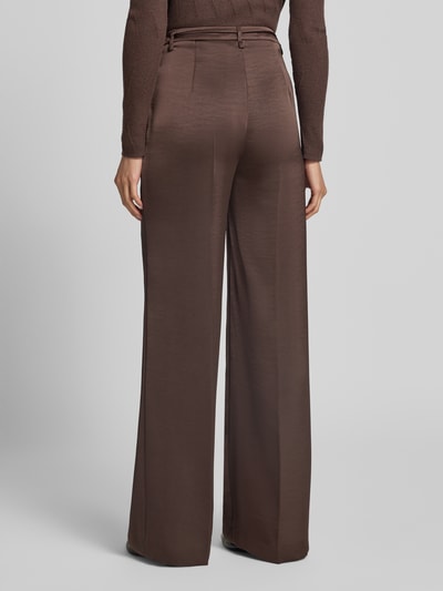 Frauenmodel trägt Schimmernde Wide Fit Hose mit Bindegürtel von Marc Cain, braune Farbe, High Waist, glatte Textur, Ganzkörperansicht Rückansicht.