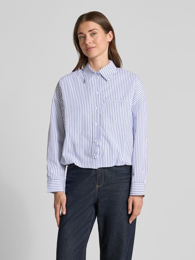 Vrouwenmodel draagt blouse met oversneden schouders van Rich & Royal in blauw-witte strepen, puur katoen, regular fit, overhemdkraag, knoopsluiting, borstzak, ruglengte maat 36: 51 cm, mouwlengte maat 36: 47 cm. Ganzlichaamsaanzicht van voren.
