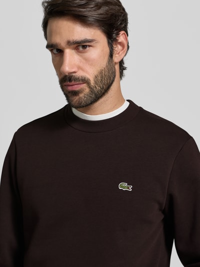 Männermodel trägt Classic Fit Sweatshirt aus Baumwoll-Mix von Lacoste, Optik: Unifarben, Logo-Stitching, Rundhals, Nahaufnahme Oberkörper.