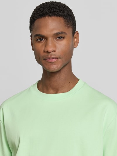 Männermodel trägt Oversized T-Shirt mit Rundhalsausschnitt von Lindbergh in Hellgrün, reine Baumwolle, Nahaufnahme Oberkörper.
