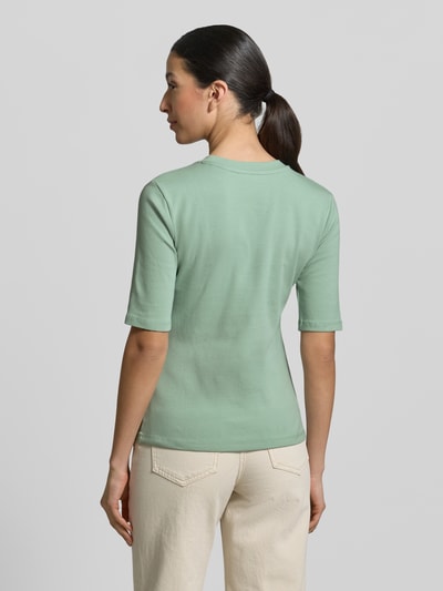 Frauenmodel trägt Slim Fit T-Shirt im Halbarm-Design von Christian Berg Woman in zartem Grün, elastischer Baumwoll-Mix, Rückansicht, Ganzkörperansicht.