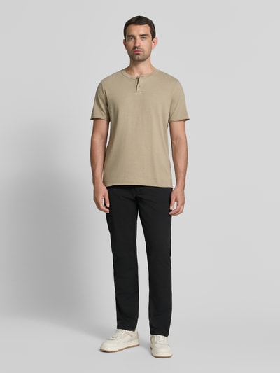 Männermodel trägt schwarze Tapered Fit Hose mit Gesäßtaschen von MCNEAL, Eingrifftaschen, Knopf- und Reißverschluss, Ganzkörperansicht von vorne