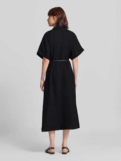Frauenmodel trägt Hemdblusenkleid aus Viskose-Leinen-Mix mit Gürtel von MORE, schwarze Farbe, lockere Textur, Ganzkörperansicht Rückansicht, A-Linie, Midikleid, V-Ausschnitt, Knopfleiste.