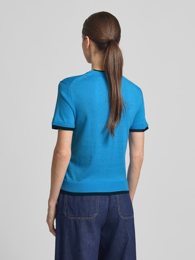 Kobiece modelka ma na sobie Strickshirt aus Leinen-Mix in Two-Tone-Machart od Stefanel, len z domieszką kaszmiru, krój slim fit, okrągły dekolt, długość tyłu 54 cm, długość rękawa 20 cm, dwa odcienie niebieskiego, gładka faktura, widok całej sylwetki od tyłu.