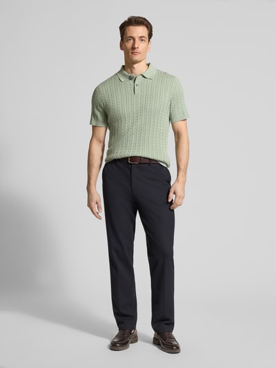 Männermodel trägt Slim Fit Poloshirt in Strick-Optik von Christian Berg Men in zartem Grün, reine Baumwolle, Ganzkörperansicht von vorne.