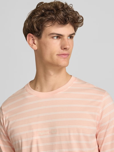 Männermodel trägt T-Shirt mit Streifenmuster und Label-Stitching von Jack & Jones aus reiner Baumwolle, Relaxed-Fit, Nahaufnahme Oberkörper.