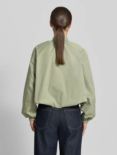 Frauenmodel trägt Blouson mit elastischen Ärmelabschlüssen und Reißverschluss von Zero in hellem Grün, Rückansicht, Ganzkörperansicht Rückansicht. Loose-Fit, kurzer Stehkragen, Raglanärmel, Rückenlänge bei Größe 36: 52 cm, Schulterbreite: 40 cm, Brustweite: 50 cm, Ärmellänge: 55 cm.