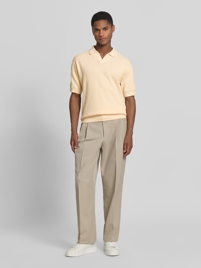 Männermodel trägt Regular Fit Poloshirt aus reiner Baumwolle Modell 'KOCELLO' von BOSS Orange, Optik: Unifarben, Struktur, Label-Patch, Polokragen, V-Ausschnitt, Kurzarm, Farbe Hellgelb, Strick, Ganzkörperansicht von vorne.