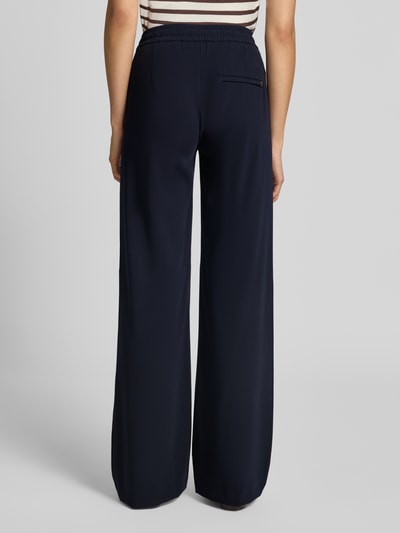 Frauenmodel trägt Wide Leg Hose mit Tunnelzug Modell 'Chrisy' von MAC in dunklem Blau, glatte Textur, Damen Weite Hose von MAC, Ganzkörperansicht Rückansicht.