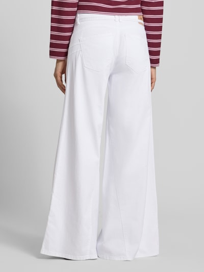 Männermodel trägt Wide Fit Jeans mit Zierschleife von MAC, elastyczna mieszanka bawełny, szeroki krój, detal kokarda, 5 kieszeni, zapięcie na guzik i zamek, szerokość w rozmiarze 36/32: 38 cm, długość nogawki od wewnątrz w rozmiarze 36/32: 82 cm, zdjęcie całej sylwetki z tyłu.