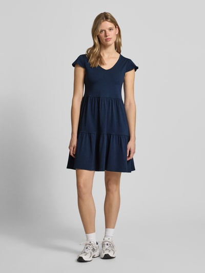 Frauenmodel trägt Minikleid im Stufen-Look mit V-Ausschnitt von REVIEW aus Baumwoll-Elasthan-Mix, A-Linie, dunkelblau, Ganzkörperansicht von vorne.