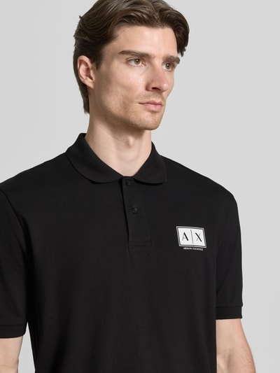 Männermodel trägt Regular Fit poloshirt mit knoopsluiting van ARMANI EXCHANGE, mix van katoen en elastaan, labelprint, zwarte kleur, mouwboordjes, ruglengte bij maat M 70 cm, nahaufnahme bovenlichaam.