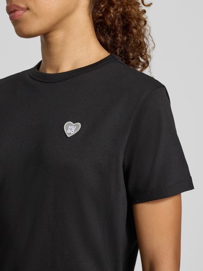 Frauenmodel trägt Regular Fit T-Shirt aus reiner Baumwolle Modell 'Damacia_9' von HUGO, schwarze Farbe, glatte Textur, Nahaufnahme Oberkörper, Damen T-Shirt von HUGO.