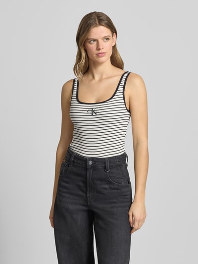 Frauenmodel trägt Trägertop in Ripp-Optik mit Logo von Calvin Klein Jeans aus Baumwoll-Elasthan-Mix, Slim-Fit, Rückenlänge 59 cm, Ganzkörperansicht von vorne.
