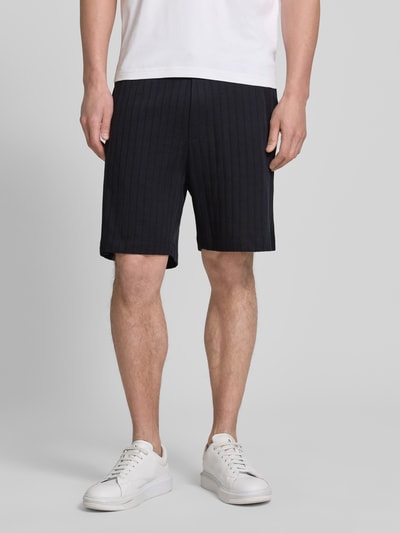 Männermodel trägt Regular Fit Shorts mit Tunnelzug Modell 'JUANITO' von JOOP! Collection, reine Baumwolle, schwarz, Ganzkörperansicht von vorne.