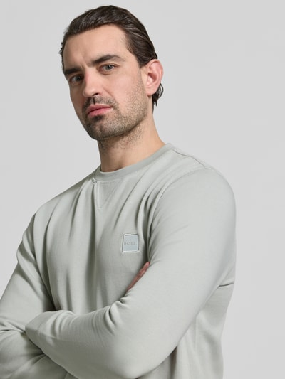 Männermodel trägt Relaxed Fit Sweatshirt aus reiner Baumwolle Modell 'WESTART' von BOSS Orange, unifarben, Nahaufnahme Oberkörper.