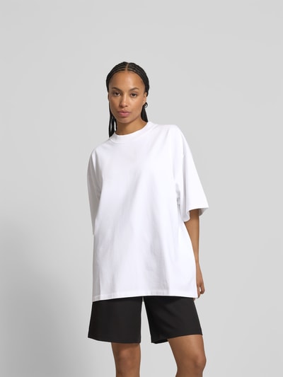Vrouwenmodel draagt Oversized T-shirt met Label-Patch van black palms, puur katoen, oversized, ronde hals, ruglengte maat S 73 cm, geheelvooraanzicht.