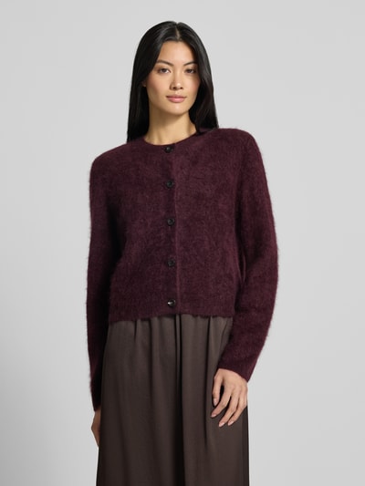 Modelka kobieca nosi kardigan rozpinany z kaszmiru z okrągłym dekoltem od windsor., krój regular fit, listwa guzikowa, bordowy, tył 43 cm, rękawy 61 cm, długi rękaw, gładka faktura, widok całej sylwetki z przodu.