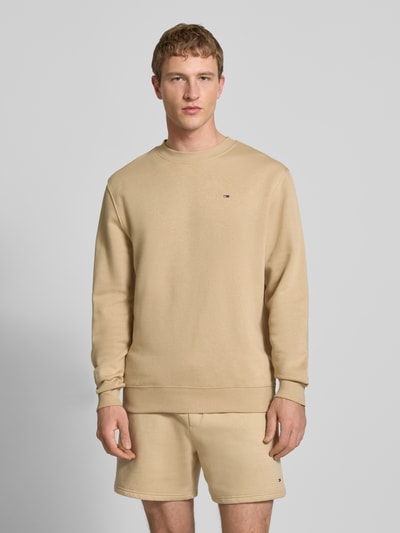 Männermodel trägt Regular Fit Sweatshirt aus Baumwoll-Mix von Tommy Jeans, Optik: Unifarben, Logo-Stitching, Ganzkörperansicht von vorne.