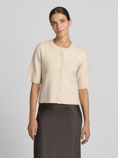 Frauenmodel trägt Regular Fit Cardigan in Strick-Optik Modell 'Iga' von VILA, beige Farbe, 1/2-Arm, Knopfleiste, Ganzkörperansicht von vorne.