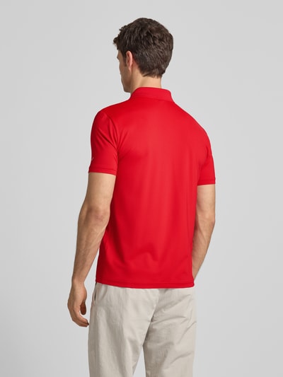 Männermodel trägt Regular Fit Poloshirt mit Logo von EA7 Emporio Armani in Rot, Material-Mix, glatte Textur, Ganzkörperansicht Rückansicht.