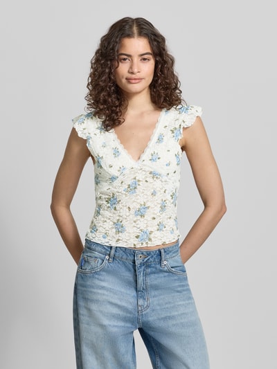 Frauenmodel trägt Slim Fit Top mit tiefem V-Ausschnitt Modell 'SAGA' von Only, Florales-Allover-Muster, Jersey, Nahaufnahme Oberkörper.