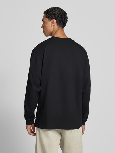 Mannelijk model draagt Longsleeve met Label-Stitching van Carhartt Work In Progress, puur katoen, relaxed fit, ronde hals, ruglengte maat M 66 cm, ganzekörperansicht rückansicht.