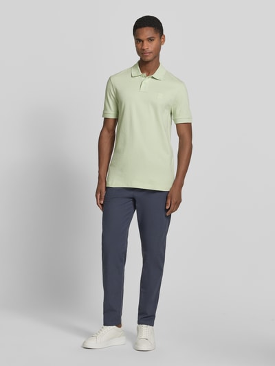 Männermodel trägt Slim Fit Poloshirt aus Baumwoll-Mix Modell 'PASSENGER' von BOSS Orange, Optik: Unifarben, Logo-Patch, Kragenform: Polokragen, 2-Knopf-Verschluss, Ärmelform: Kurzarm, Material: Baumwoll-Mix, Ganzkörperansicht von vorne.