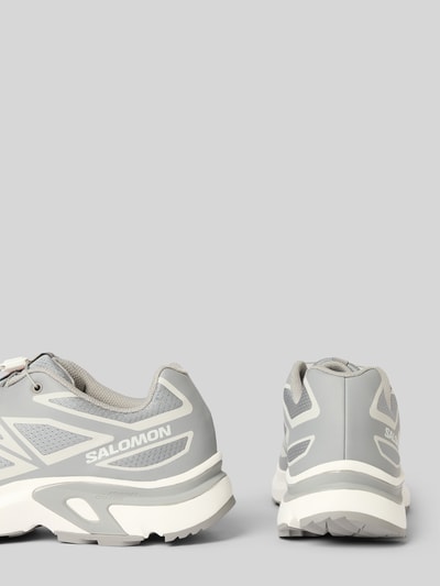 Produktfoto, grauer Sneaker mit profilierter Sohle Modell 'XT-EVR' von Salomon, abgerundete Spitze, Logo, weiße Details, strukturierte Oberfläche