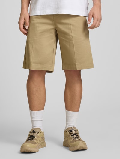 Männermodel trägt Bermudas mit französischen Eingrifftaschen von Dickies, Reine Baumwolle, Straight Fit, Knopf-Reißverschluss, Ganzkörperansicht von vorne.