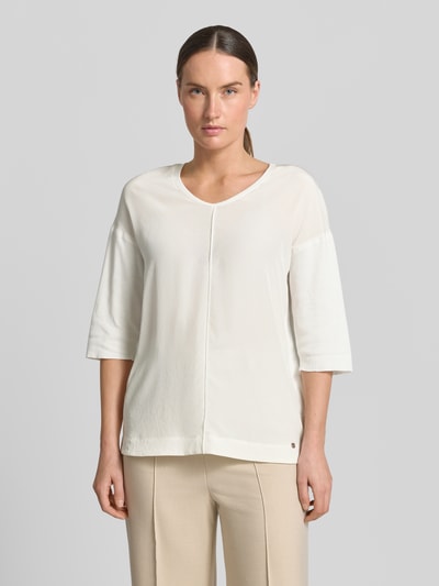 Frauenmodel trägt T-Shirt mit Ärmelaufschlag und Rundhalsausschnitt von Marc Cain, Baumwoll-Mix mit Stretch-Anteil, Straight Fit, Label-Detail, cremefarben, Rückenlänge bei Größe 36: 62 cm, Ganzkörperansicht von vorne.
