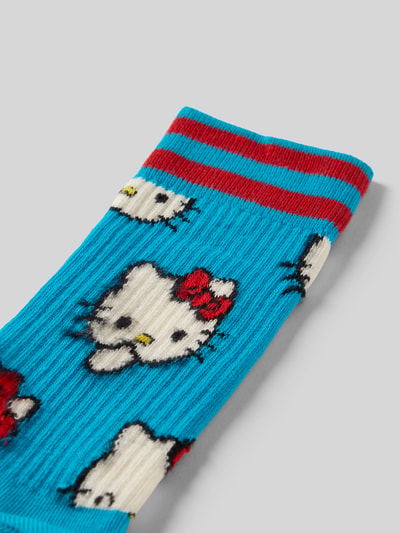 Produktfoto, blaue Socken aus Baumwoll-Elasthan-Mix mit rotem Streifen, Hello Kitty Muster und Label-Detail, Modell 'HELLO KITTY SMILES' von Happy Socks