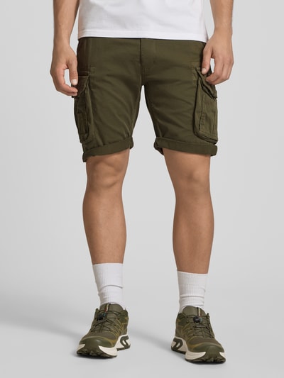 Männermodel trägt Shorts mit Cargotaschen Modell 'CREW SHORT' von Alpha Industries in Olivgrün, Regular Fit, Ganzkörperansicht von vorne.