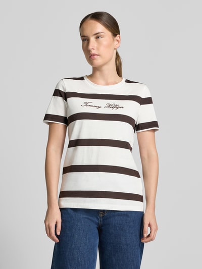 Vrouwenmodel draagt Regular Fit T-shirt uit puur katoen van Tommy Hilfiger, wit met brede bruine strepen, Ganzkörperaanzicht van voren.