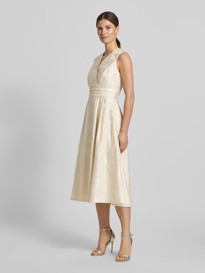 Frauenmodel trägt Regular Fit Midikleid mit floralem Allover-Stitching von Rinascimento in Beige mit V-Ausschnitt und Wickel-Optik, Ganzkörperansicht von vorne.