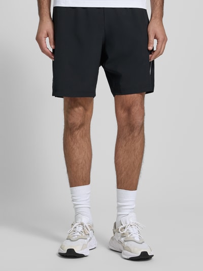 Männermodel trägt Shorts mit elastischem Bund und Logo von EA7 Emporio Armani, Schwarz, Material-Mix mit Stretch-Anteil, Regular Fit, Eingrifftaschen, Ganzkörperansicht von vorne.