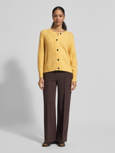 Modelka nosi Regular Fit Strickjacke aus Woll-Mix mit Alpaka-Anteil Modell 'LULU' od Selected Femme, żółty rippstrick, pełen przód.